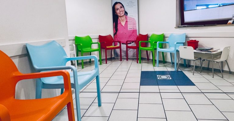 Wartezimmer EIn Wartezimmer mit bunten Kunststoffstühlen auf weißen Fliesen.